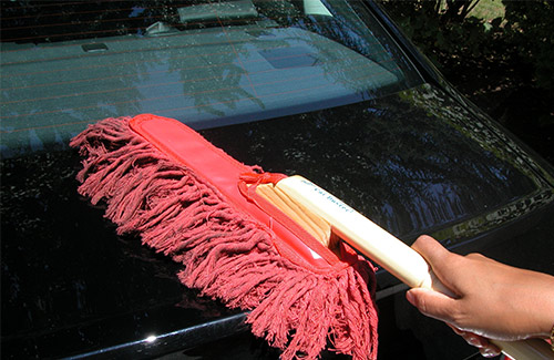 Dusting the car before waterless car wash
