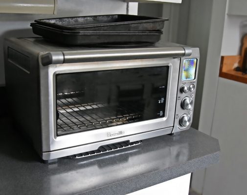 a toaster oven placed on kitchen shelf